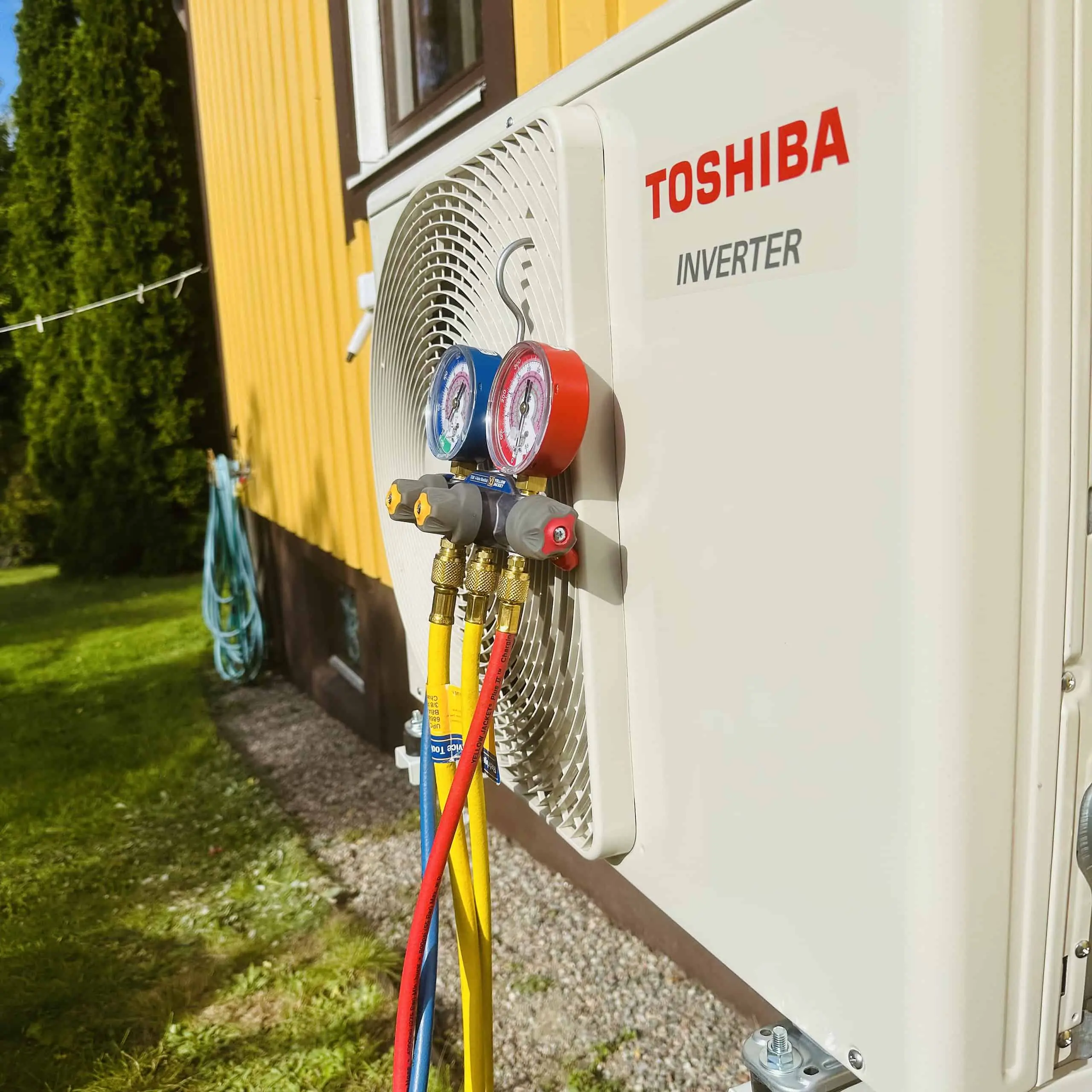 Toshiba Inverter luftvärmepump utomshusdel på husfasad som trycktestas